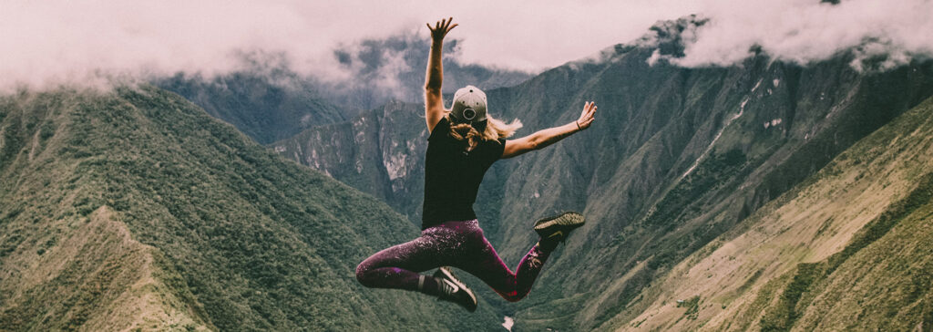 woman jumping on a mountain