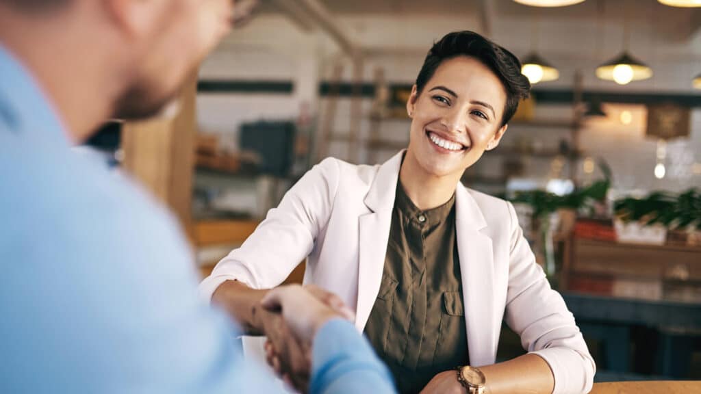 woman getting promotion at work with handshake