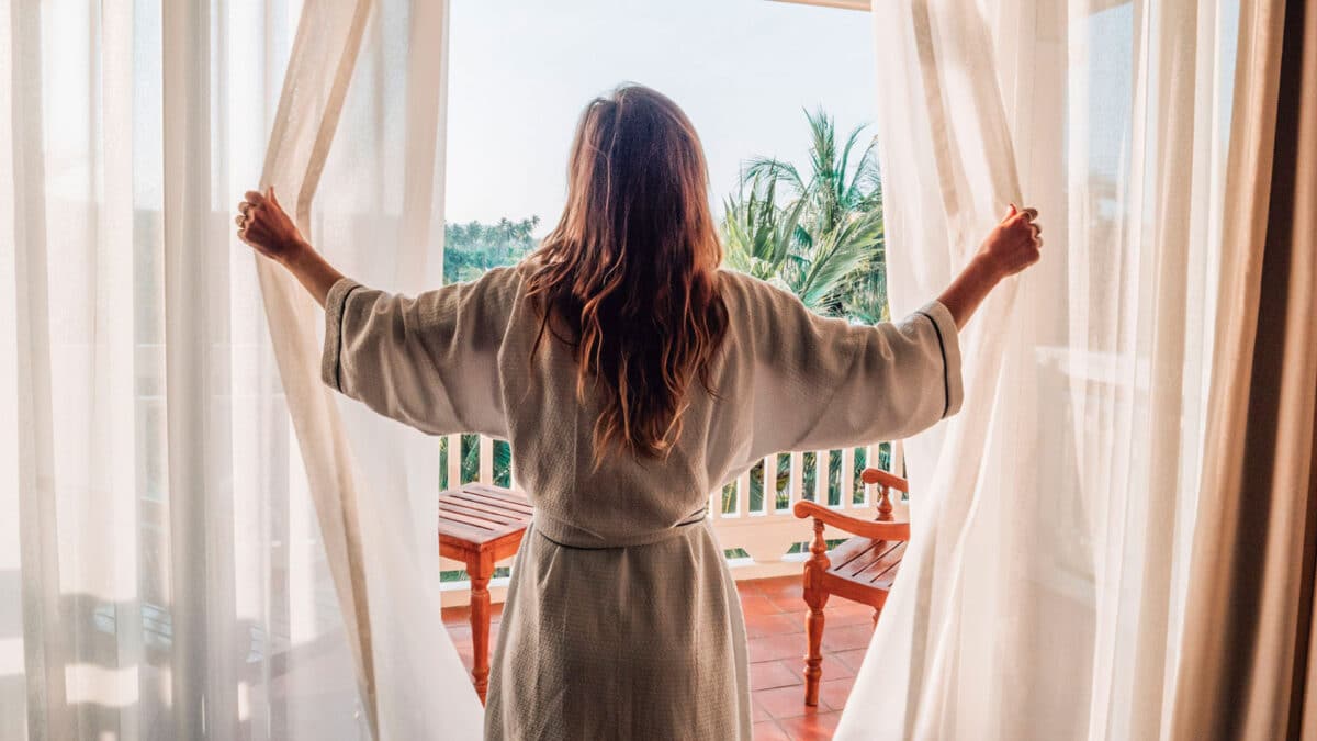 woman checks out the view from her hotel room