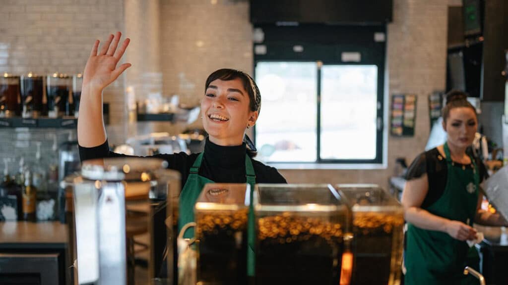 starbucks barista waving to customer