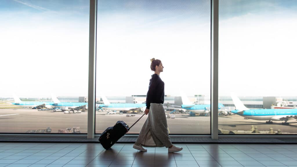 woman with suitcase walking through airport