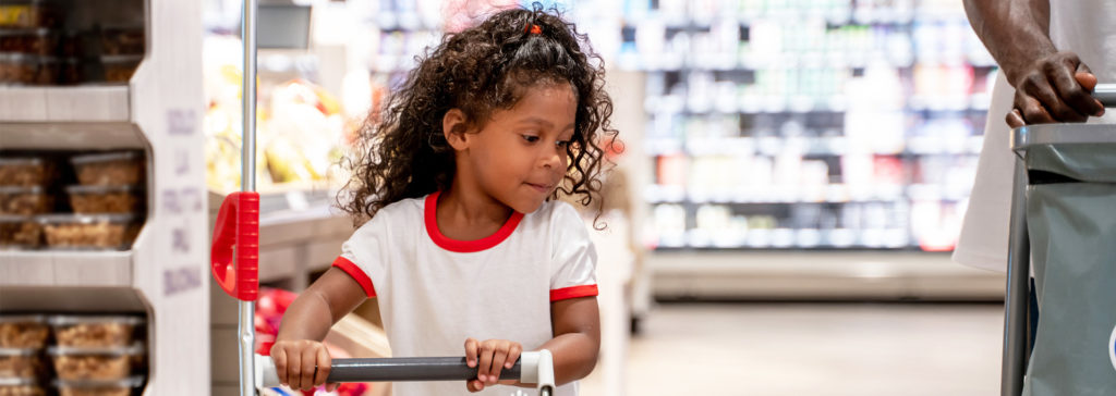 small girl shopping with her family