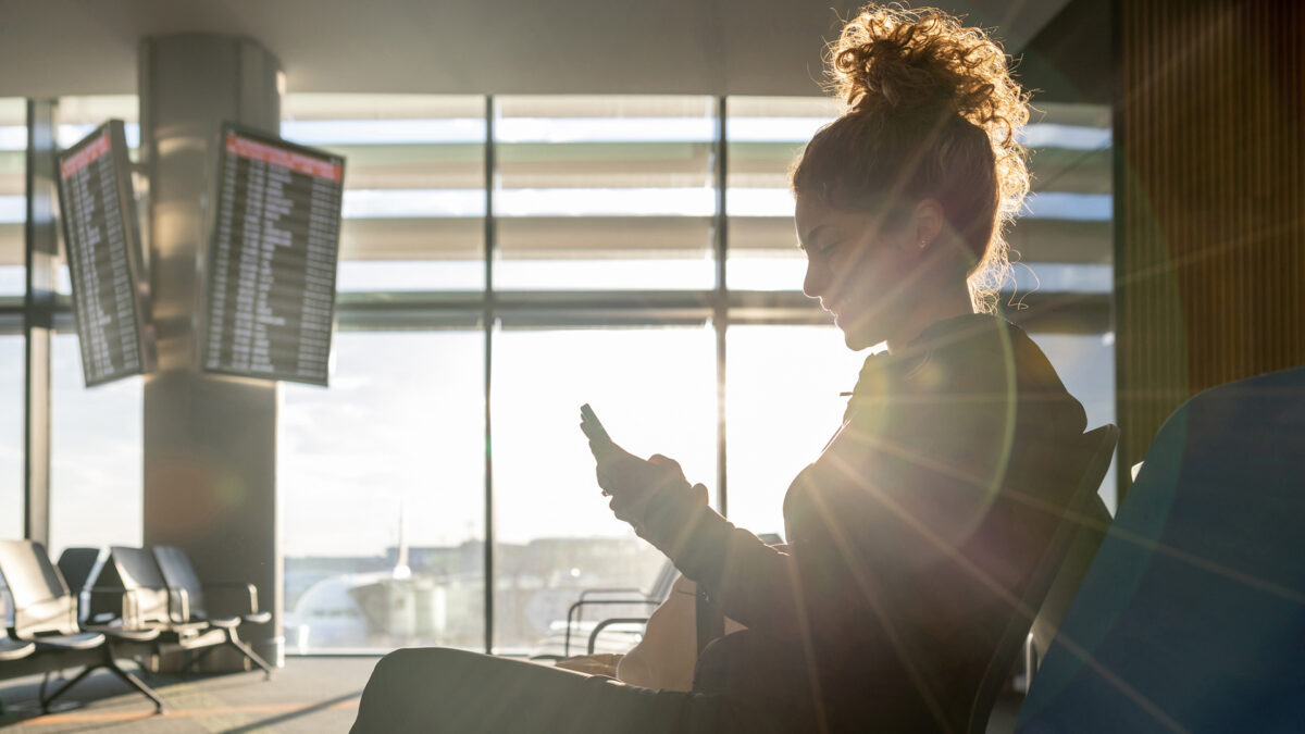 woman at airport looking at phone